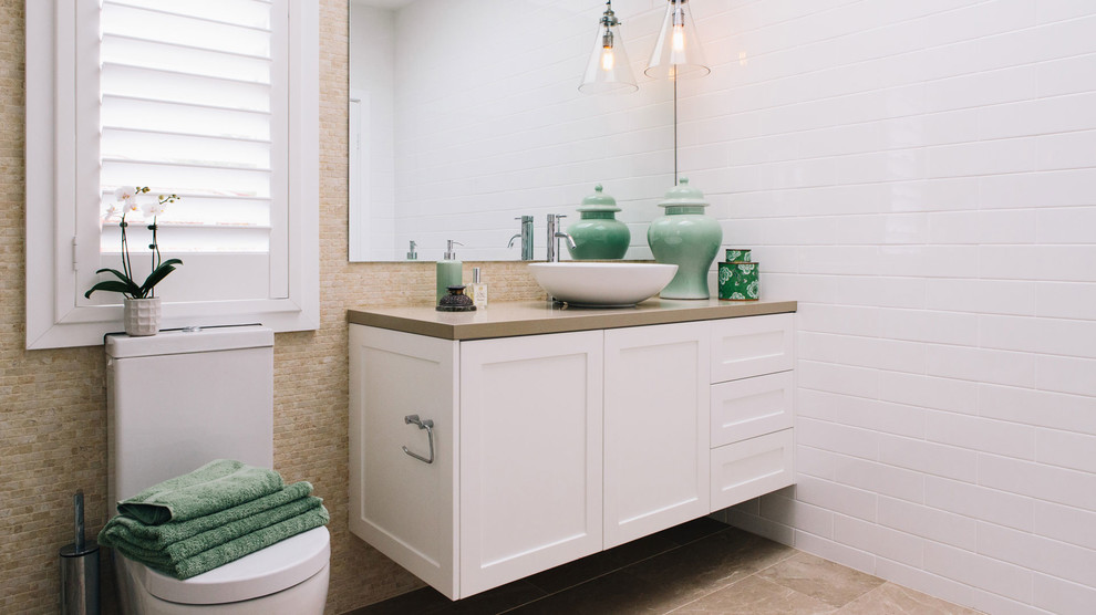 Inredning av ett klassiskt badrum, med skåp i shakerstil, vita skåp, ett fristående badkar, en öppen dusch, en toalettstol med separat cisternkåpa, beige kakel, brun kakel, vit kakel, vita väggar och ett fristående handfat
