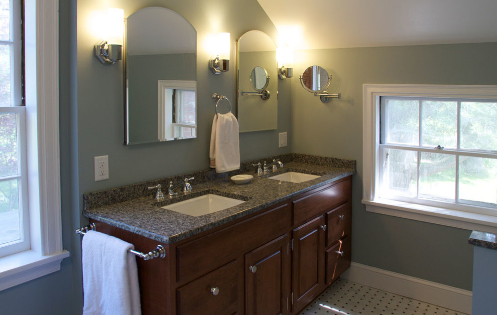 Cette photo montre une salle de bain chic en bois brun avec un placard à porte plane, un plan de toilette en granite, un carrelage blanc, un mur bleu et un sol en carrelage de céramique.