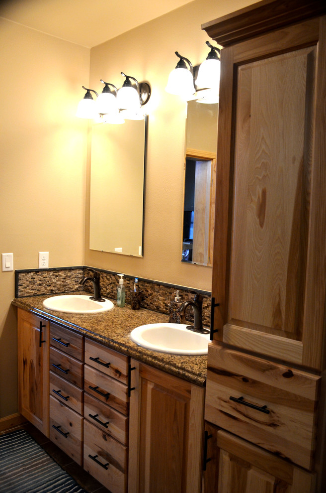 Esempio di una stanza da bagno padronale stile rurale di medie dimensioni con ante con bugna sagomata, ante in legno chiaro, pareti beige, lavabo da incasso e top in laminato