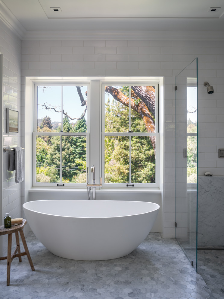 Inspiration för ett stort funkis grå grått en-suite badrum, med ett fristående badkar, en kantlös dusch, vit kakel, vita väggar, mosaikgolv, grått golv, med dusch som är öppen, släta luckor, vita skåp, tunnelbanekakel, ett undermonterad handfat och marmorbänkskiva