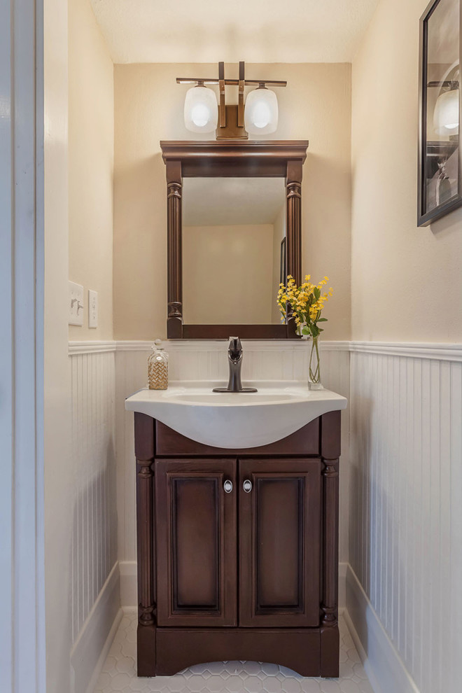 Foto på ett stort amerikanskt badrum med dusch, med ett konsol handfat, möbel-liknande, skåp i mörkt trä, marmorbänkskiva, en toalettstol med hel cisternkåpa, vit kakel, porslinskakel, beige väggar och klinkergolv i porslin