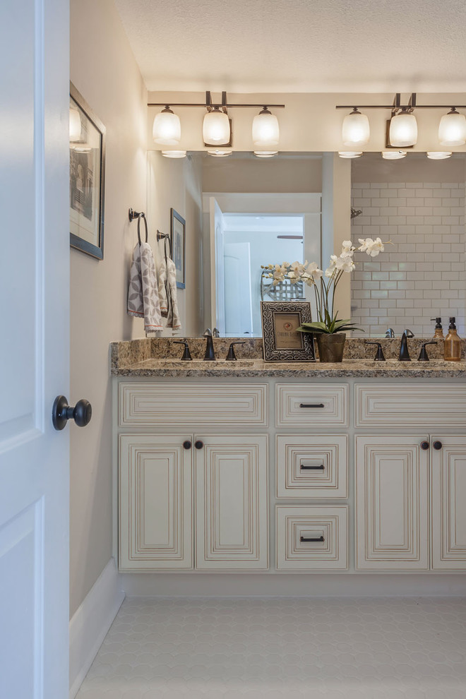 Inspiration for a large traditional family bathroom in Tampa with an integrated sink, freestanding cabinets, white cabinets, marble worktops, a shower/bath combination, white tiles, porcelain tiles, beige walls and porcelain flooring.