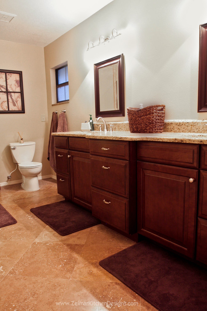 Ejemplo de cuarto de baño tradicional de tamaño medio con lavabo bajoencimera, armarios con paneles con relieve, puertas de armario de madera oscura, encimera de granito y baldosas y/o azulejos beige