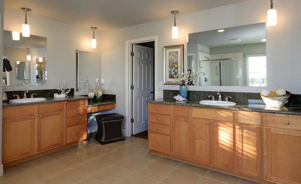 Immagine di una stanza da bagno chic con lavabo da incasso, ante in stile shaker, ante in legno chiaro e top in granito