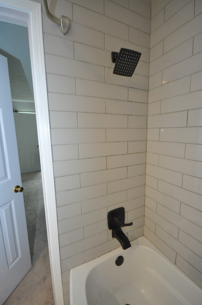 Idée de décoration pour une salle de bain bohème avec un placard à porte shaker, des portes de placard blanches, une baignoire posée, un combiné douche/baignoire, un mur blanc, un sol en bois brun, une vasque, un plan de toilette en bois, un sol gris et une cabine de douche avec un rideau.