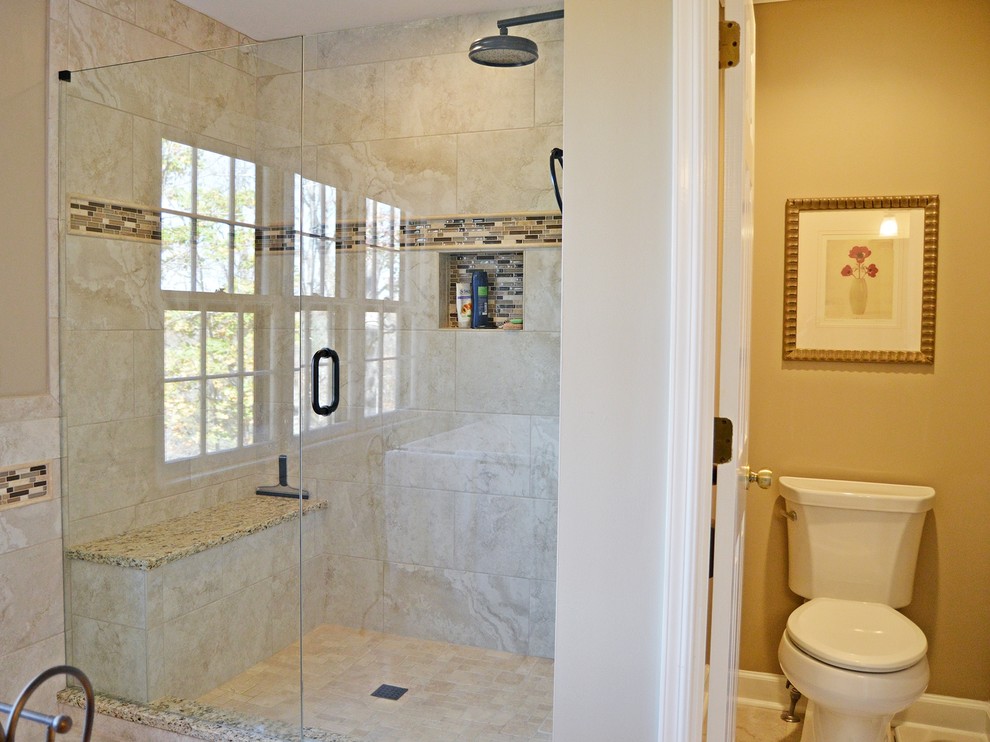 Photo of a large contemporary ensuite bathroom in Atlanta with raised-panel cabinets, medium wood cabinets, a freestanding bath, an alcove shower, a one-piece toilet, beige tiles, porcelain tiles, beige walls, porcelain flooring, granite worktops and a submerged sink.