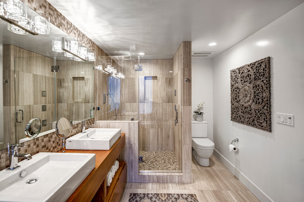 Inspiration pour une salle de bain principale design en bois brun de taille moyenne avec une vasque, un placard à porte plane, un plan de toilette en bois, une baignoire posée, une douche d'angle, WC séparés, un carrelage beige, mosaïque, un mur blanc et un sol beige.