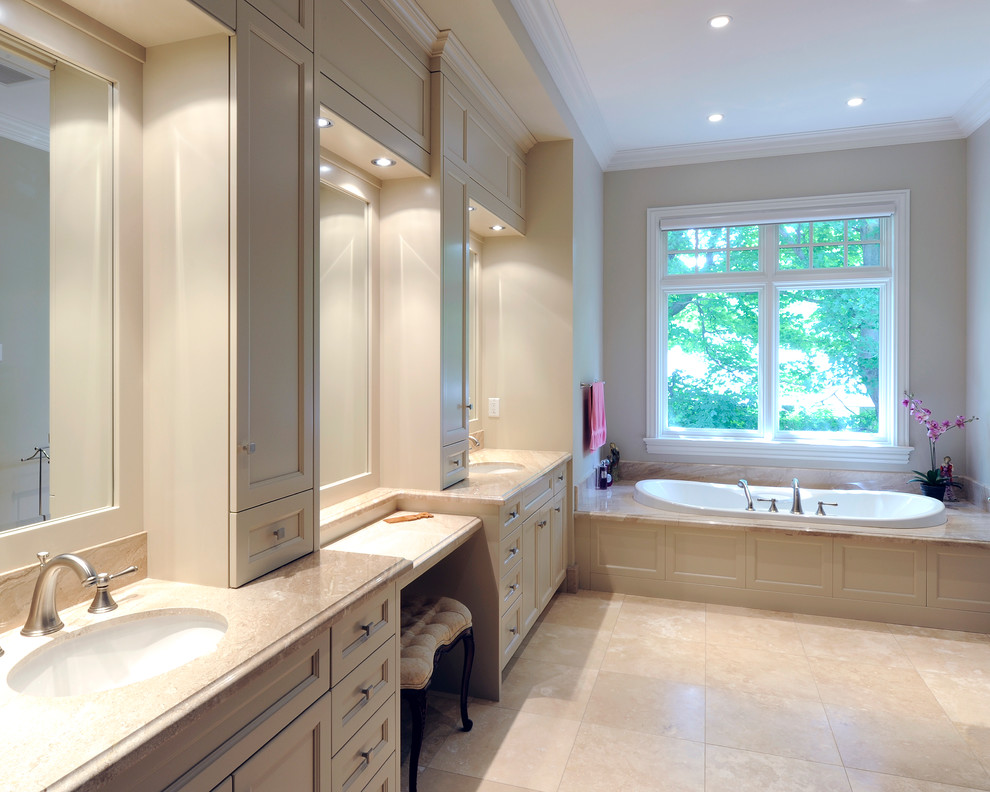 Klassisk inredning av ett stort en-suite badrum, med luckor med infälld panel, beige skåp, ett badkar i en alkov, beige väggar, klinkergolv i keramik, ett undermonterad handfat och marmorbänkskiva