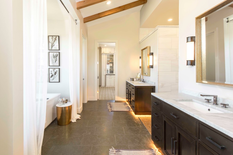 Пример оригинального дизайна: главная ванная комната в стиле кантри с темными деревянными фасадами, белой плиткой, белыми стенами, врезной раковиной и серым полом