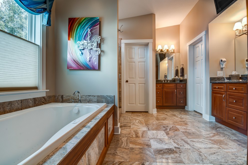 Mid-sized farmhouse master multicolored tile and ceramic tile ceramic tile bathroom photo in Other with an integrated sink, raised-panel cabinets, medium tone wood cabinets, granite countertops, a hot tub, a one-piece toilet and beige walls