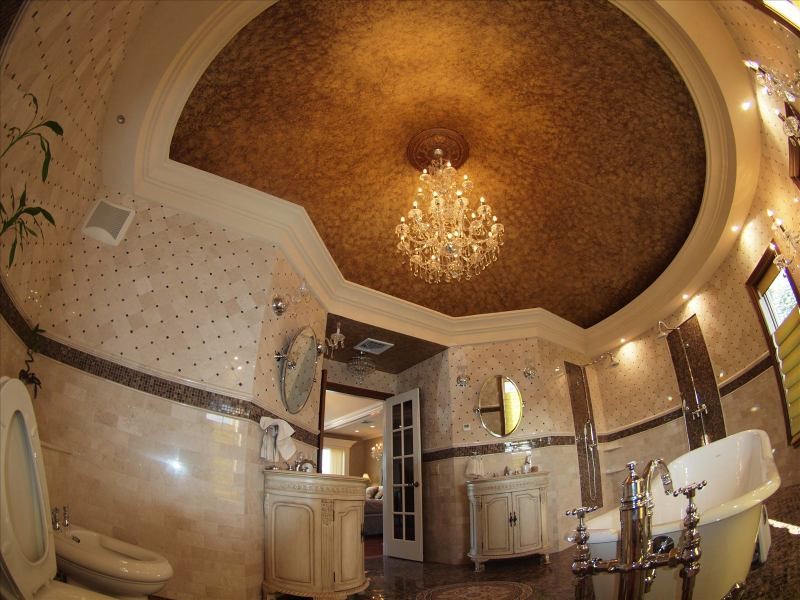 This is an example of a mediterranean ensuite bathroom in New York with a submerged sink, freestanding cabinets, beige cabinets, marble worktops, a claw-foot bath, a walk-in shower, a one-piece toilet, beige tiles, stone tiles, beige walls and marble flooring.