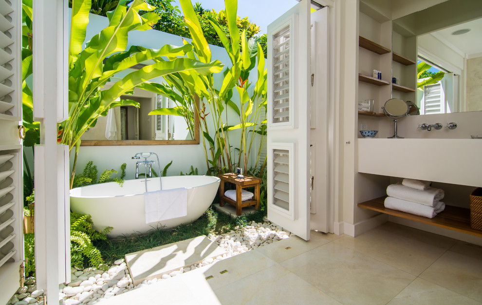 Cette photo montre une salle de bain principale exotique avec une baignoire indépendante et un sol beige.