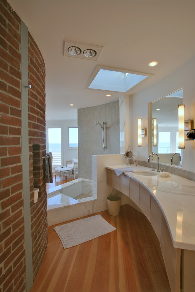 Inspiration pour une grande salle de bain principale design en bois clair avec une douche ouverte, un mur blanc, un lavabo encastré, un placard à porte plane, un carrelage gris et un carrelage de pierre.