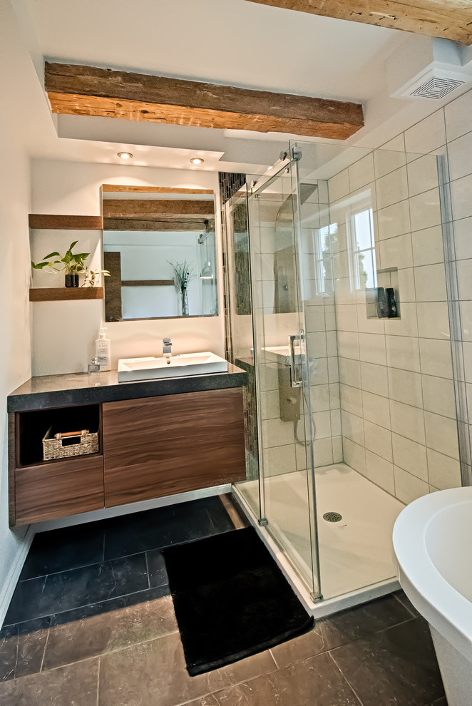 Exemple d'une petite salle de bain principale éclectique en bois brun avec un placard à porte plane, un plan de toilette en stratifié, une baignoire indépendante, une douche d'angle, un carrelage gris, des carreaux de céramique et un sol en carrelage de céramique.