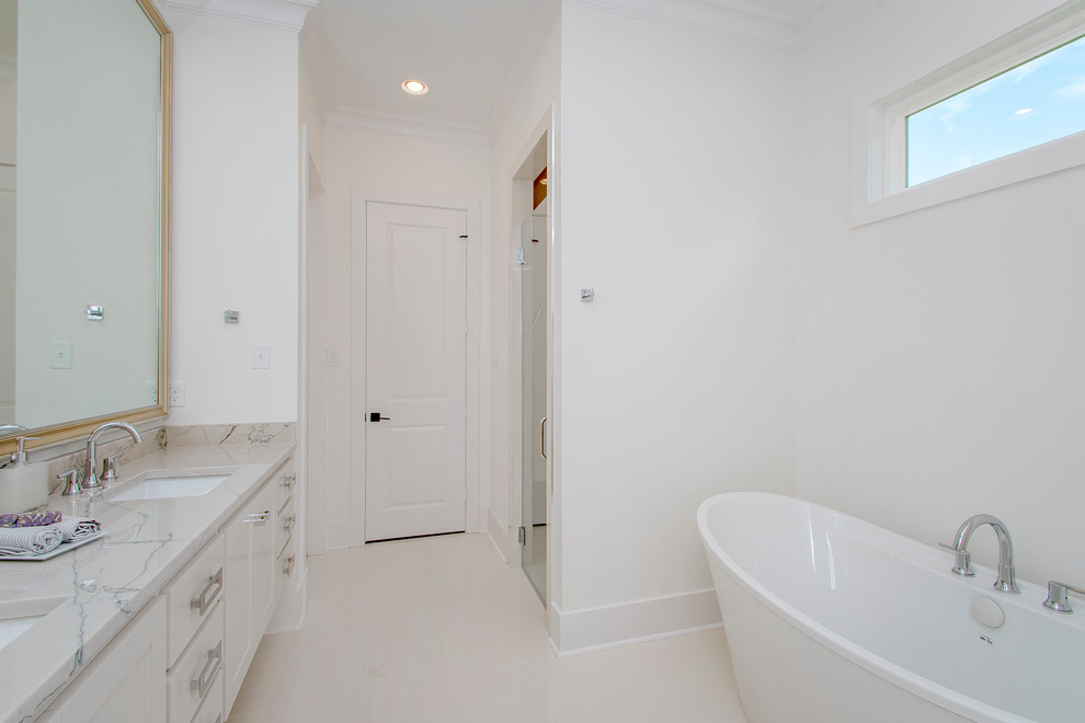 Пример оригинального дизайна: главная ванная комната среднего размера в классическом стиле с фасадами с выступающей филенкой, белыми фасадами, отдельно стоящей ванной, душем в нише, белыми стенами, врезной раковиной, мраморной столешницей, серым полом, душем с распашными дверями и серой столешницей