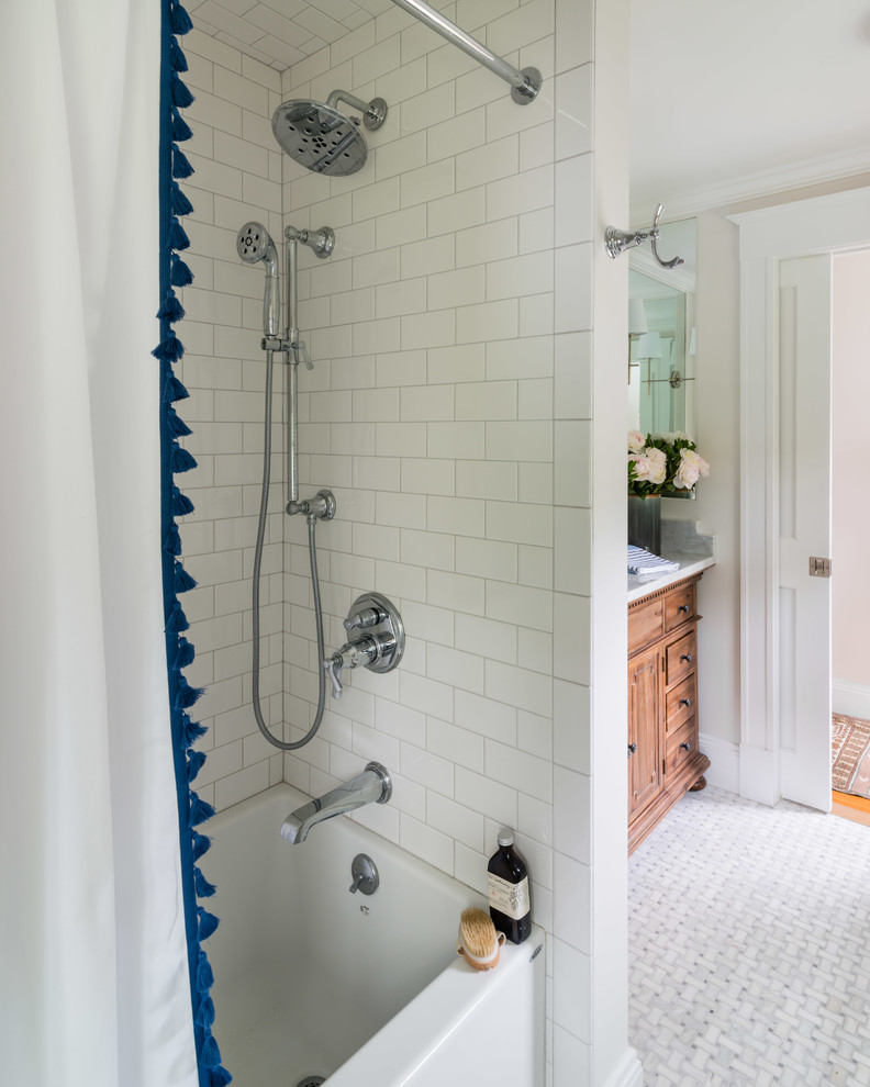 Modelo de cuarto de baño principal, clásico renovado, pequeño, con armarios tipo mueble, puertas de armario de madera oscura, bañera empotrada, combinación de ducha y bañera, sanitario de dos piezas, baldosas y/o azulejos blancos, baldosas y/o azulejos de porcelana, paredes grises, suelo de mármol, lavabo bajoencimera, encimera de mármol, suelo gris, ducha con cortina y encimeras blancas