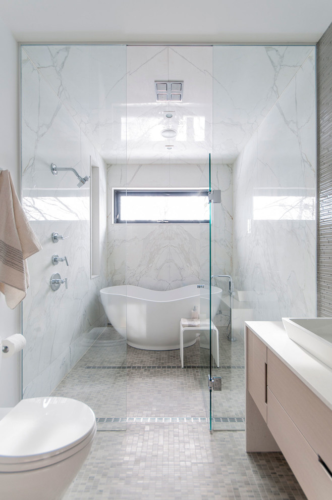 Réalisation d'une salle de bain design avec une baignoire indépendante et mosaïque.