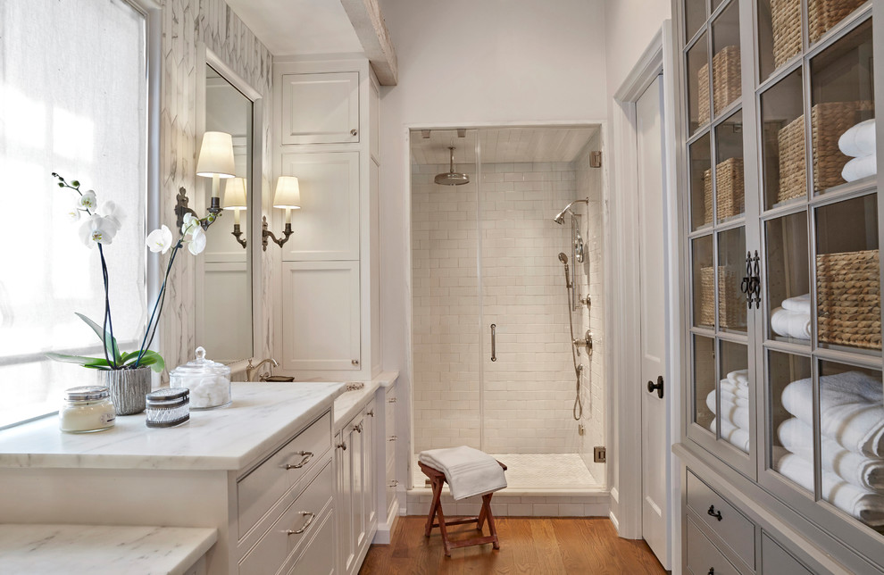Idéer för ett stort klassiskt en-suite badrum, med luckor med profilerade fronter, vita skåp, en dusch i en alkov, vit kakel, tunnelbanekakel, vita väggar, ljust trägolv, ett undermonterad handfat, marmorbänkskiva, beiget golv och dusch med gångjärnsdörr