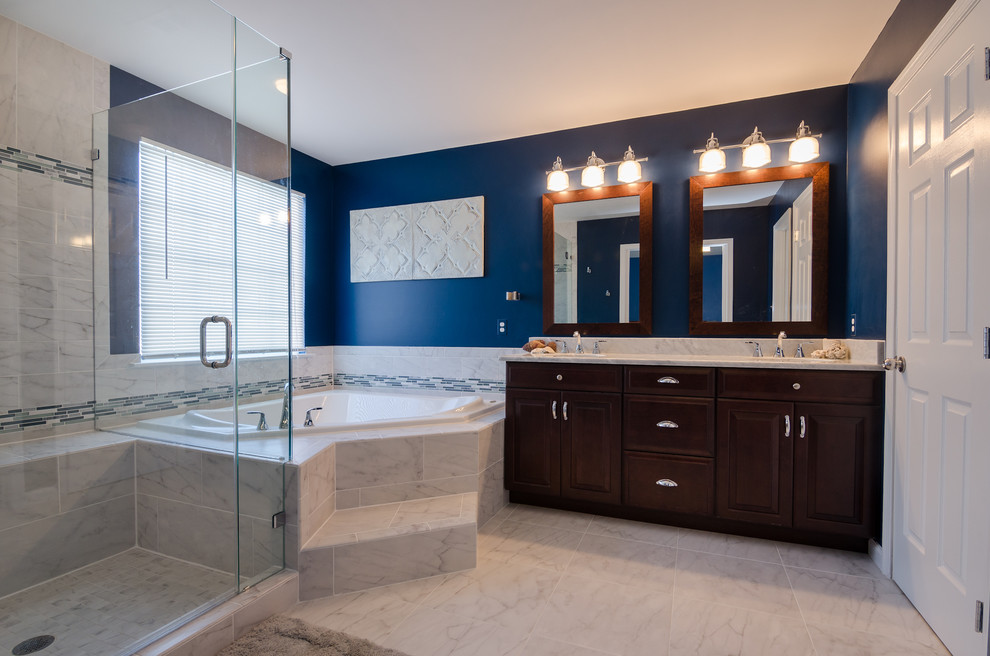 Design ideas for a large traditional ensuite bathroom in DC Metro with a submerged sink, raised-panel cabinets, medium wood cabinets, granite worktops, a built-in bath, a corner shower, a two-piece toilet, white tiles, porcelain tiles, blue walls and porcelain flooring.