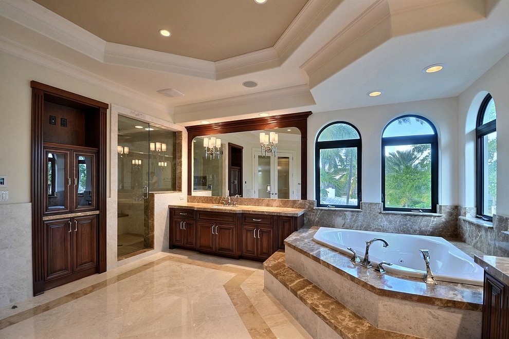 Свежая идея для дизайна: ванная комната в классическом стиле с врезной раковиной, темными деревянными фасадами, мраморной столешницей, угловой ванной, бежевой плиткой, каменной плиткой и мраморным полом - отличное фото интерьера