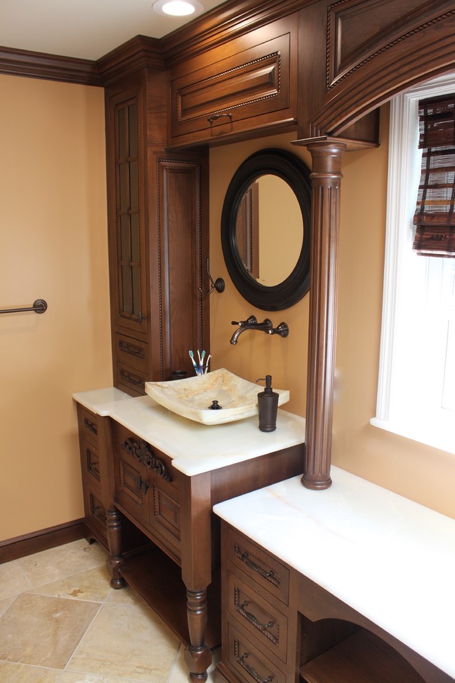 Aménagement d'une grande douche en alcôve principale classique en bois foncé avec un placard avec porte à panneau surélevé, WC séparés, un carrelage beige, un carrelage de pierre, un sol en travertin, une vasque et un plan de toilette en onyx.