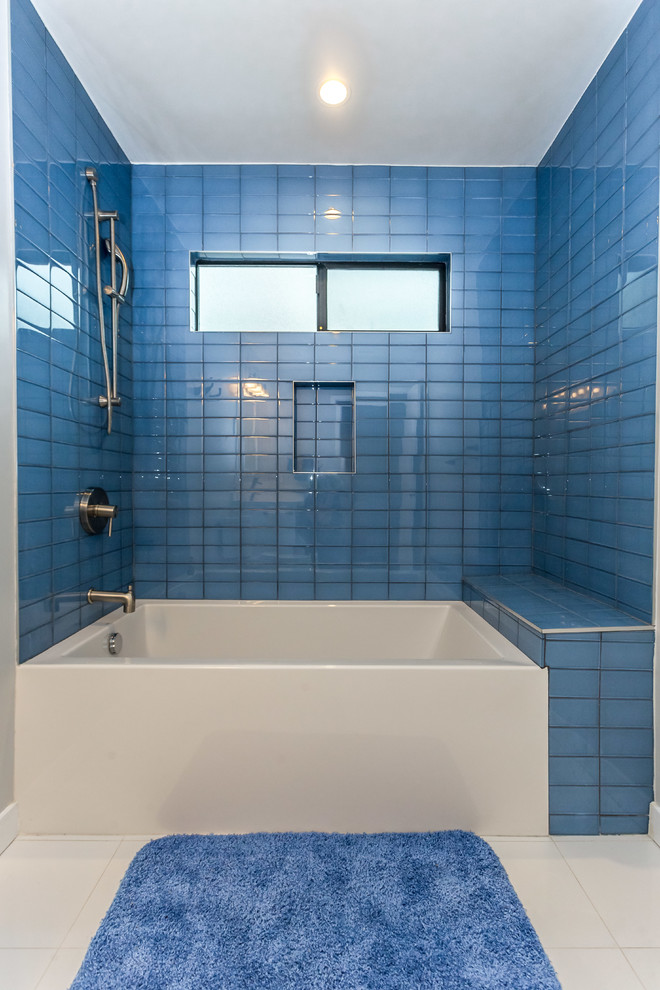 Idéer för att renovera ett stort funkis badrum med dusch, med släta luckor, vita skåp, ett badkar i en alkov, en toalettstol med separat cisternkåpa, blå kakel, glaskakel, grå väggar, klinkergolv i porslin, ett undermonterad handfat, bänkskiva i kvarts och en dusch/badkar-kombination
