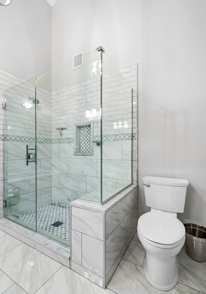Cette image montre une grande salle de bain principale traditionnelle avec un placard avec porte à panneau surélevé, des portes de placard blanches, une baignoire posée, une douche ouverte, WC séparés, un carrelage blanc, du carrelage en marbre, un mur gris, un sol en carrelage de porcelaine, un lavabo encastré, un plan de toilette en quartz modifié, un sol blanc, une cabine de douche à porte battante, un plan de toilette blanc, un banc de douche, meuble double vasque, meuble-lavabo sur pied et un plafond voûté.
