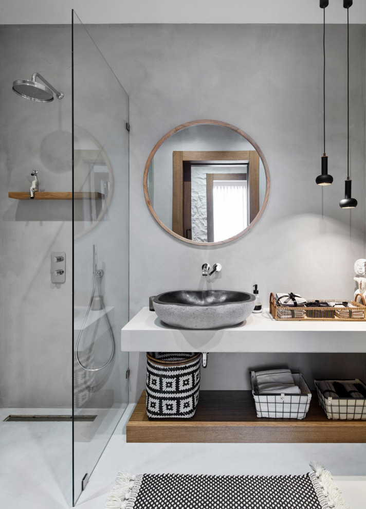 This is an example of an expansive mediterranean shower room bathroom in Other with open cabinets, a walk-in shower, grey tiles, a vessel sink, grey floors, an open shower, white worktops, a single sink and a floating vanity unit.