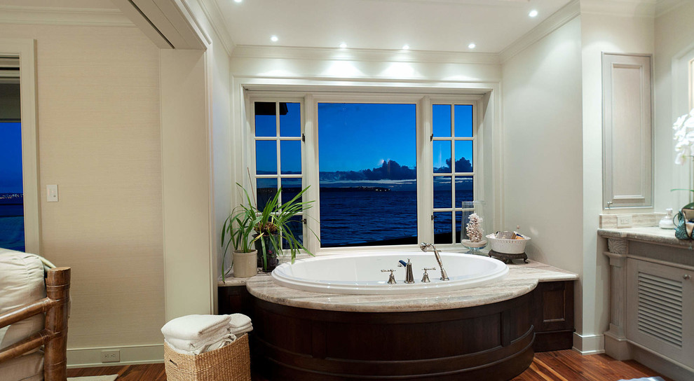 Bild på ett mellanstort funkis en-suite badrum, med luckor med lamellpanel, vita skåp, ett platsbyggt badkar, vita väggar, mellanmörkt trägolv, ett nedsänkt handfat, granitbänkskiva och brunt golv