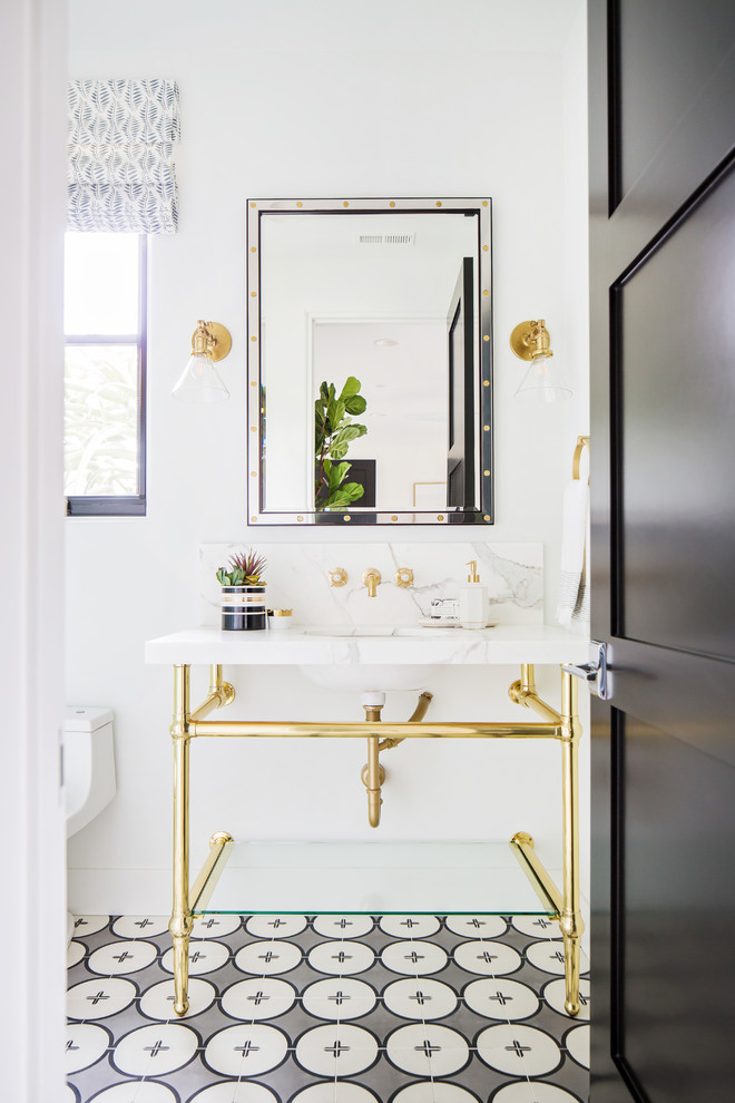 Esempio di una stanza da bagno mediterranea con lavabo da incasso, top in marmo e pavimento bianco