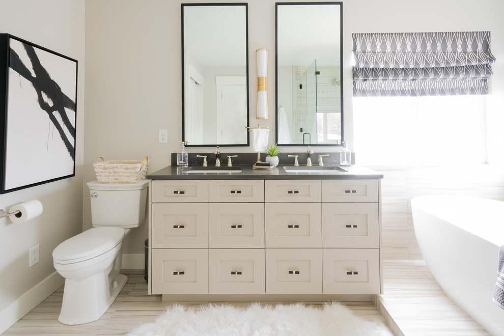 Ejemplo de cuarto de baño tradicional renovado con armarios estilo shaker, puertas de armario beige, bañera exenta, paredes grises, lavabo bajoencimera y suelo beige