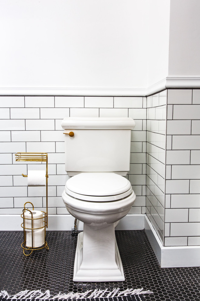 Foto på ett mellanstort vintage badrum, med ett badkar med tassar, en toalettstol med separat cisternkåpa, vit kakel, tunnelbanekakel, vita väggar och ett piedestal handfat