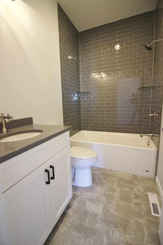 Aménagement d'une salle de bain principale campagne avec un placard à porte shaker, des portes de placard blanches, une douche ouverte, un carrelage blanc, un carrelage métro, un mur gris, une vasque et un plan de toilette en stratifié.
