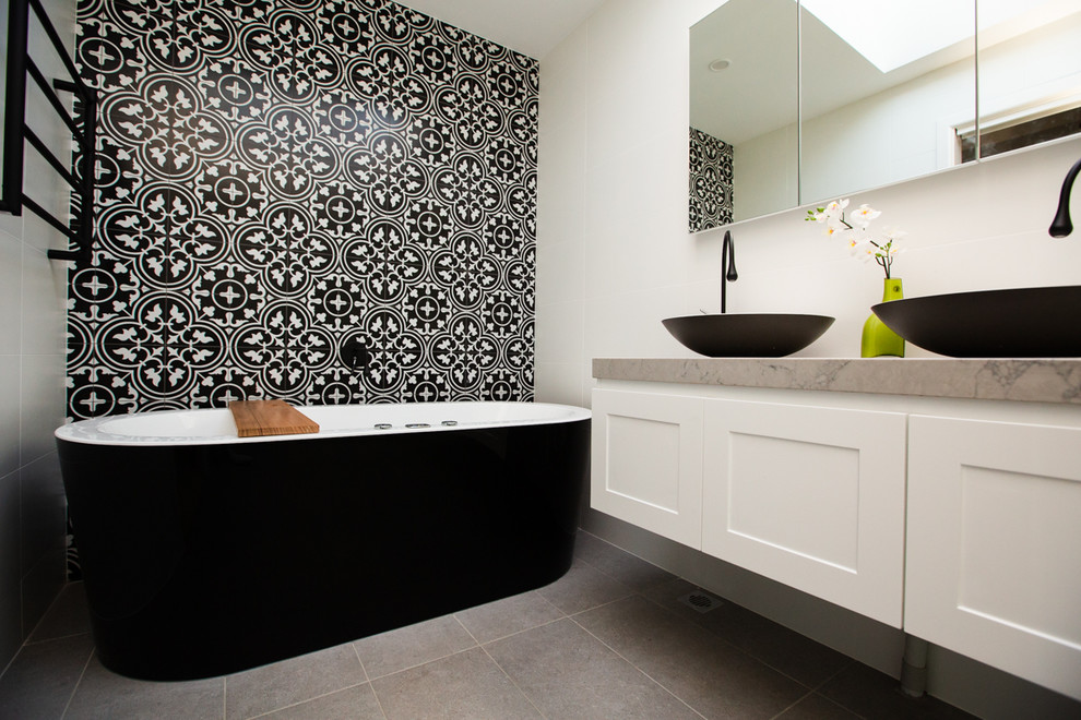 Exemple d'une salle de bain tendance de taille moyenne avec une baignoire indépendante, une douche d'angle, un carrelage noir et blanc et un plan de toilette en marbre.