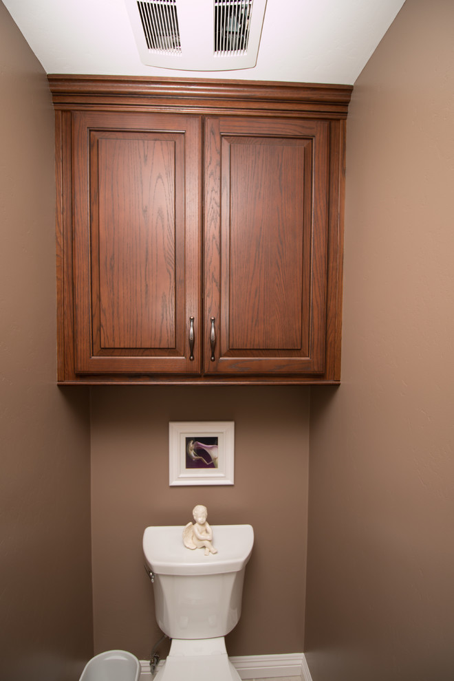 Idées déco pour un petit WC et toilettes classique en bois brun avec un lavabo encastré, un placard avec porte à panneau surélevé, un plan de toilette en quartz modifié, WC séparés, un carrelage beige, un carrelage métro, un mur marron et un sol en carrelage de porcelaine.