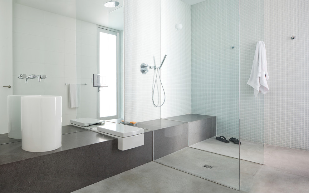 Idee per una stanza da bagno minimalista con lavabo a bacinella, piastrelle di vetro, pareti bianche, pavimento in cemento e doccia a filo pavimento