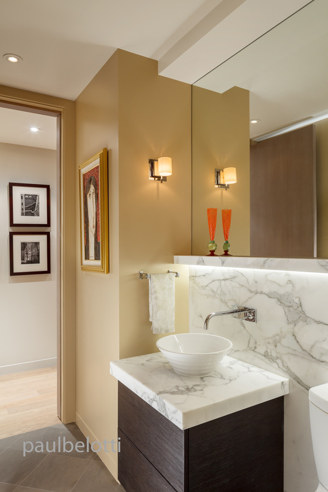 Aménagement d'une salle de bain contemporaine en bois foncé de taille moyenne avec une vasque, un placard à porte plane, un plan de toilette en marbre, WC séparés et un sol en carrelage de porcelaine.
