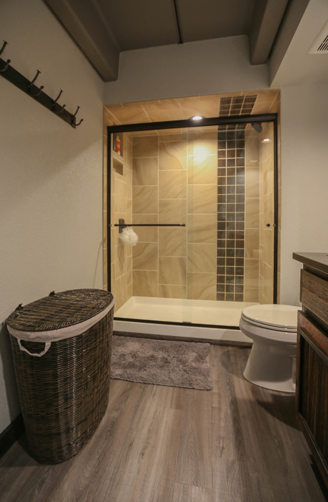 Bild på ett litet rustikt svart svart en-suite badrum, med luckor med upphöjd panel, skåp i mörkt trä, en toalettstol med separat cisternkåpa, brun kakel, mellanmörkt trägolv, ett undermonterad handfat, granitbänkskiva, beiget golv och dusch med skjutdörr