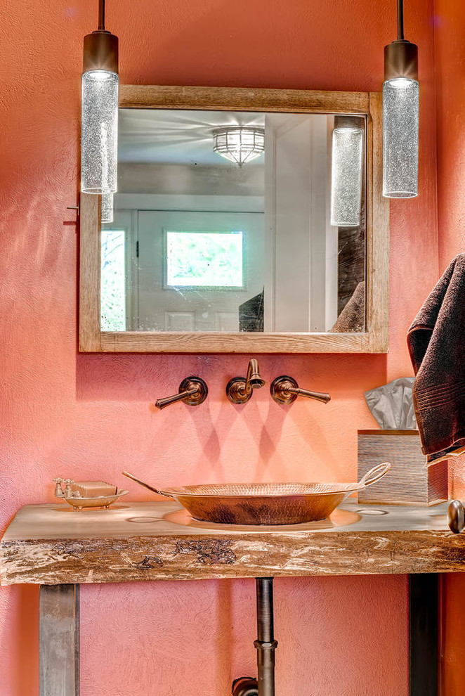 Foto på ett litet rustikt badrum med dusch, med ett fristående handfat, öppna hyllor, skåp i mellenmörkt trä, träbänkskiva, orange väggar och mellanmörkt trägolv