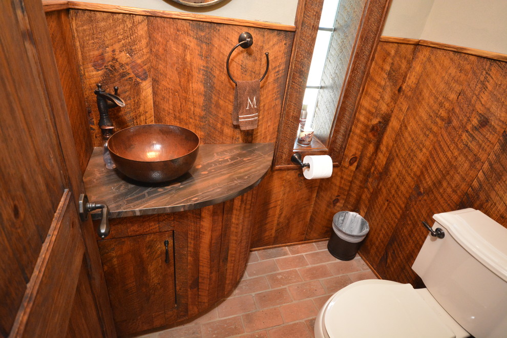 ニューヨークにあるお手頃価格の小さなラスティックスタイルのおしゃれな浴室 (一体型トイレ	、茶色いタイル、茶色い壁、レンガの床、ベッセル式洗面器、珪岩の洗面台) の写真