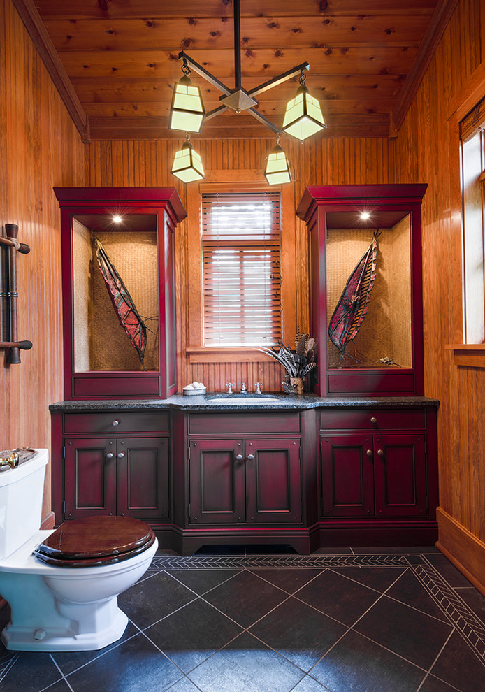 Rustik inredning av ett badrum, med luckor med infälld panel, röda skåp, en toalettstol med separat cisternkåpa, svart kakel, skiffergolv och ett undermonterad handfat