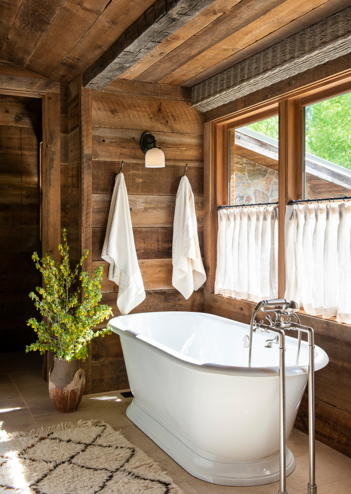 Diseño de cuarto de baño principal rústico con bañera exenta, paredes marrones y suelo beige
