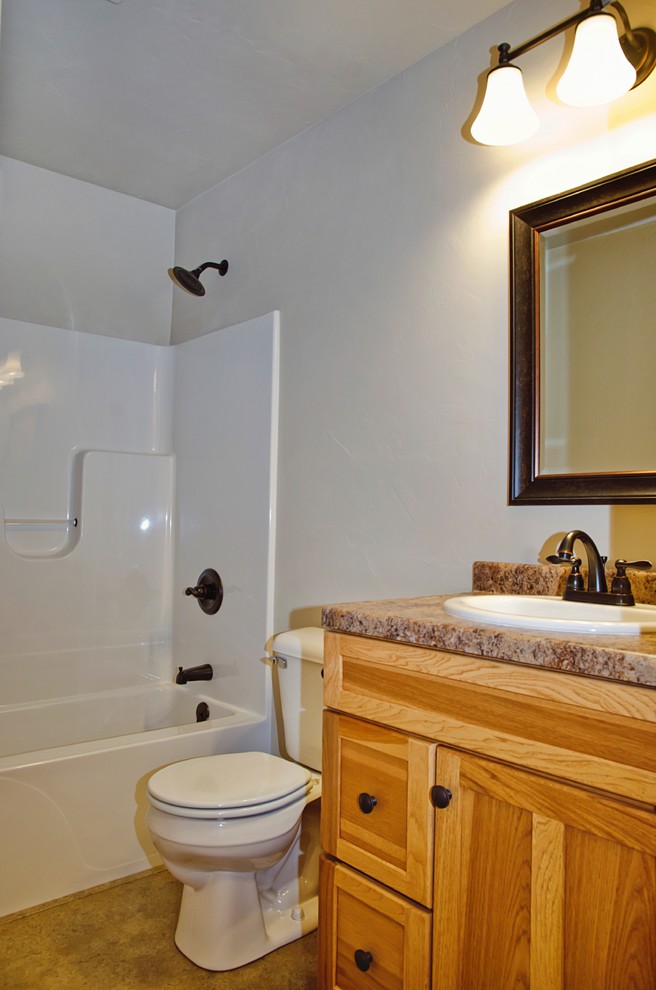 Idée de décoration pour une salle de bain principale chalet en bois clair de taille moyenne avec un placard avec porte à panneau encastré, une baignoire posée, un combiné douche/baignoire, WC séparés, un carrelage beige, un mur beige, un sol en linoléum, un lavabo posé, un plan de toilette en stratifié, un sol marron et une cabine de douche avec un rideau.