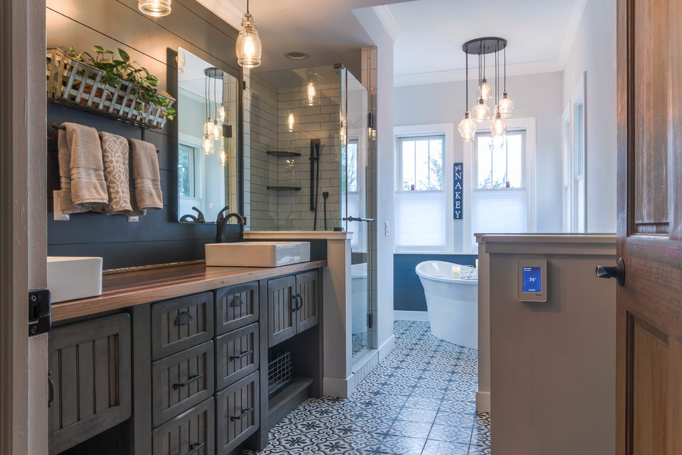 Idéer för mellanstora rustika brunt en-suite badrum, med luckor med infälld panel, bruna skåp, ett fristående badkar, en hörndusch, blå väggar, mosaikgolv, ett fristående handfat, träbänkskiva, blått golv, dusch med gångjärnsdörr och vit kakel