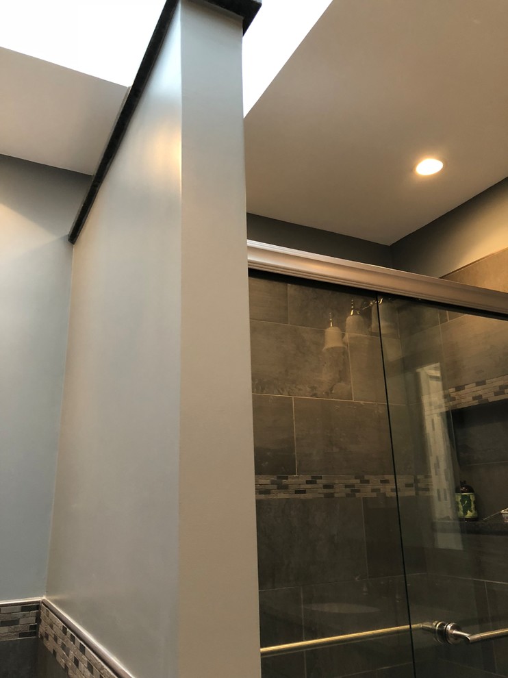 Cette photo montre une salle de bain principale nature en bois foncé de taille moyenne avec une baignoire en alcôve, une douche d'angle, WC à poser, un carrelage gris, des carreaux de céramique, un mur gris, un sol en carrelage de céramique, un lavabo encastré, un plan de toilette en granite, un sol gris et une cabine de douche à porte coulissante.