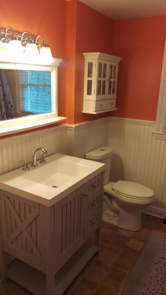 ニューヨークにあるラスティックスタイルのおしゃれな浴室 (フラットパネル扉のキャビネット、茶色いキャビネット、分離型トイレ、オレンジの壁、一体型シンク、珪岩の洗面台) の写真