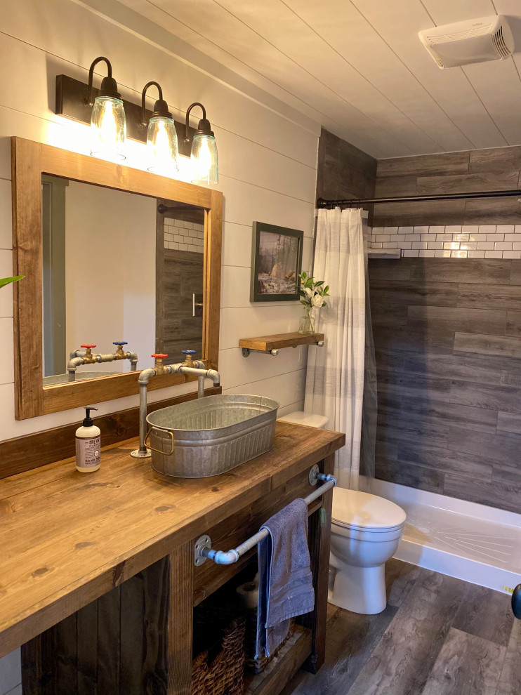 Inspiration för ett mellanstort rustikt brun brunt badrum med dusch, med möbel-liknande, bruna skåp, en öppen dusch, en toalettstol med hel cisternkåpa, vita väggar, vinylgolv, ett fristående handfat, träbänkskiva och grått golv