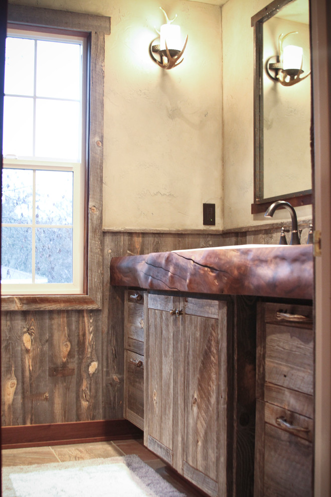 Kleines Uriges Duschbad mit Schränken im Used-Look, Waschtisch aus Holz, Schieferboden, braunen Fliesen und beiger Wandfarbe in Sonstige