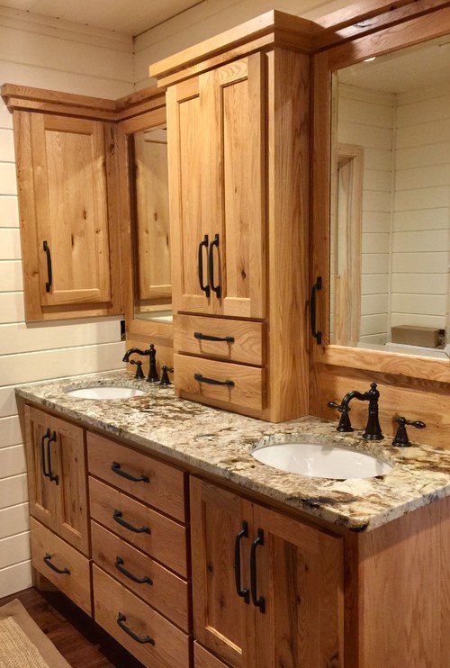 Rustic-style bathroom cabinets with natural oak wood vanity, granite countertop, and double sinks in a Canadian cottage