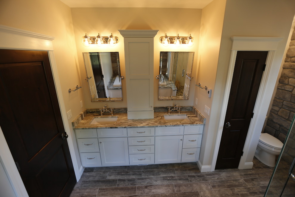 Design ideas for a medium sized rustic ensuite bathroom in Cedar Rapids with shaker cabinets, white cabinets, a built-in bath, a corner shower, a one-piece toilet, brown tiles, ceramic tiles, beige walls, ceramic flooring, a submerged sink and marble worktops.